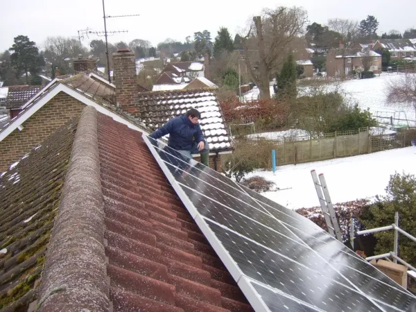 Solar panels installed on roof during winter with snow visible